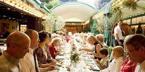 Hansens Gamle Familiehave under et selskab med langbord og gæster.