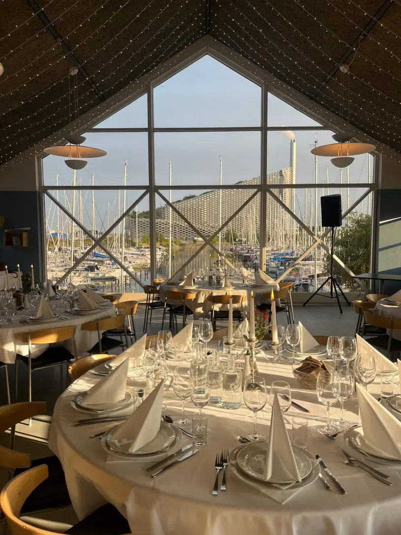 Restaurant Lynettens opdækkede selskabsrum med høje vinduer mod havnen.