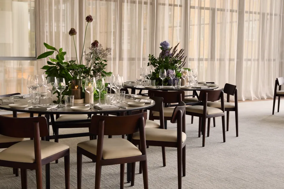 1 Hotel Copenhagens lyse arrangementsrum med runde opdækkede borde.
