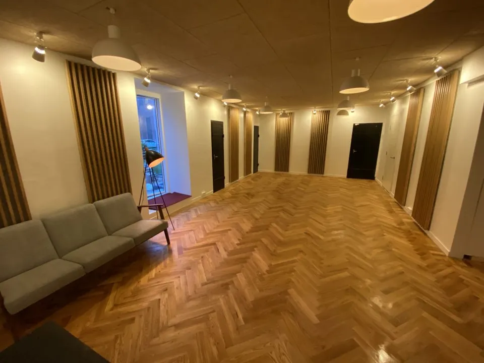 Stuen i Transformerstationen med trægulv og sofa.