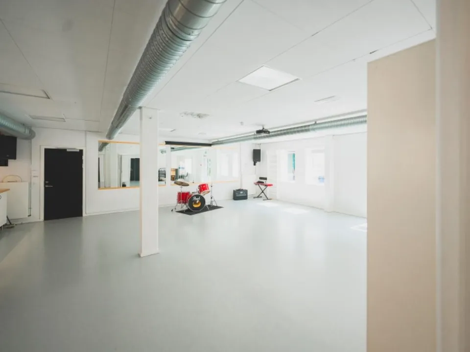 Lille Sal i Osramhuset med lyst gulv, søjler og store vinduer.