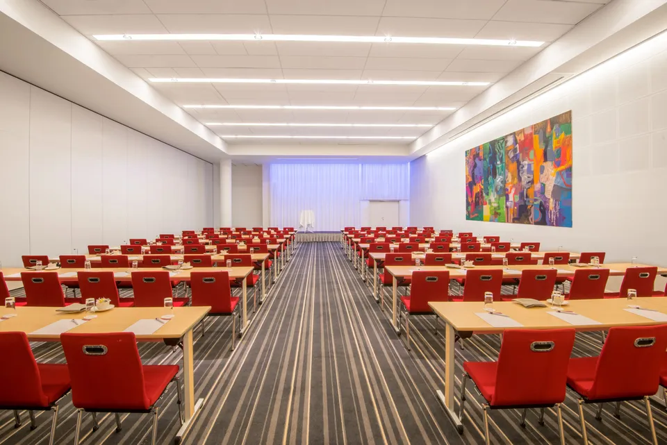 Everest Ballroom v. Crowne Plaza Copenhagen Towers: Lyst konferencelokale med bordrækker, røde stole og et stort vægmaleri.