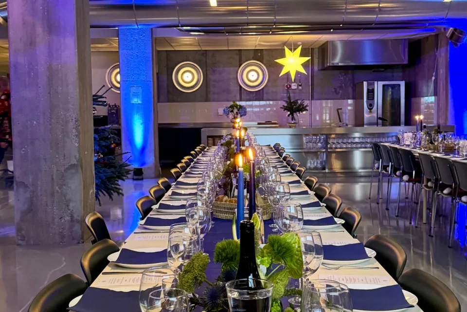 Noon Event: dækket langbord under blå belysning i et industrilokale med store søjler.