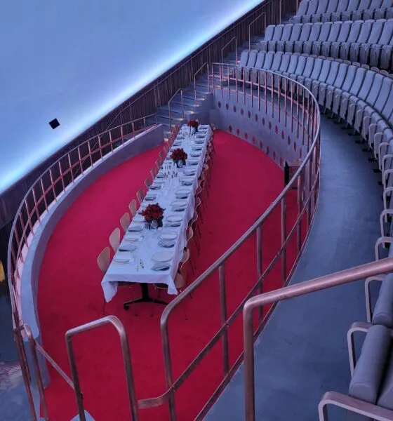 Kuppelsalen Private Dining v. Planetarium: et dækket langbord på et rødt gulvareal mellem kuppelsalens sæderækker.