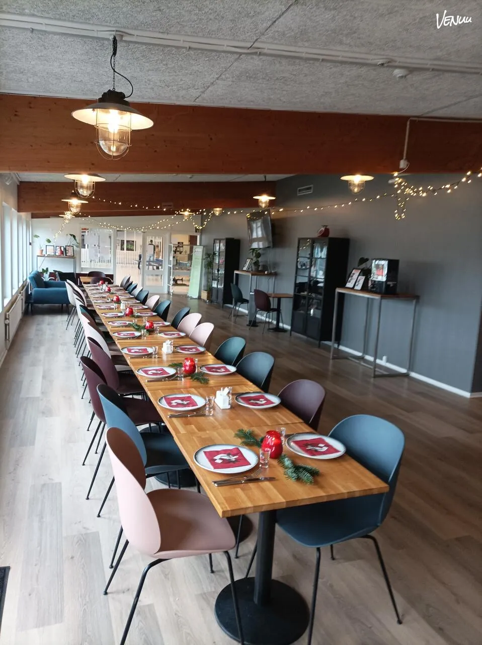 Valby Hallen Cafe og Bistro: dækket langbord med stole i et caféområde med trægulv.