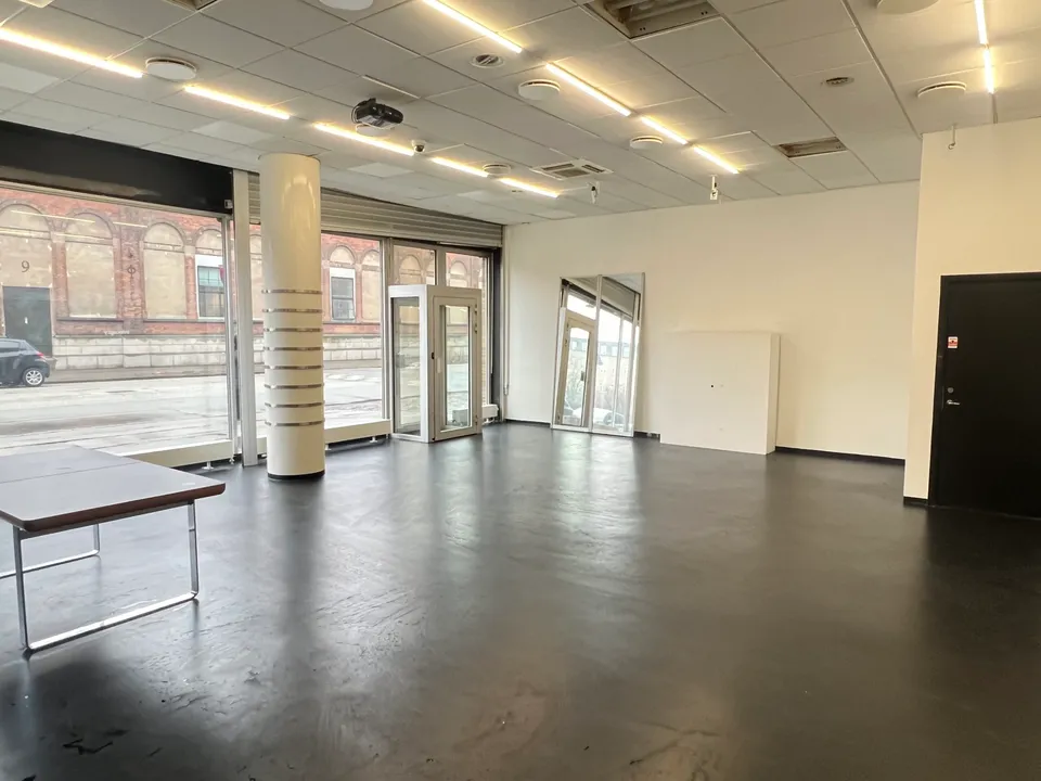 Studio Space på Nørrebro: lyst studiorum med søjler, store vinduer og mørkt gulv.