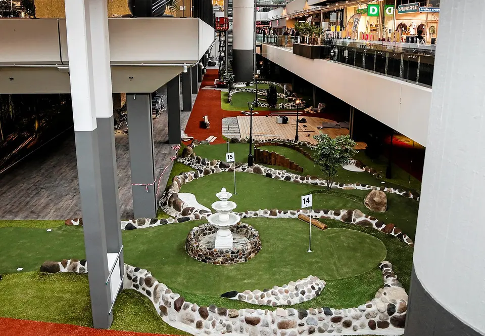 Cecilie´s City2: Minigolfbaner med sten og grøn belægning set fra et øvre niveau.