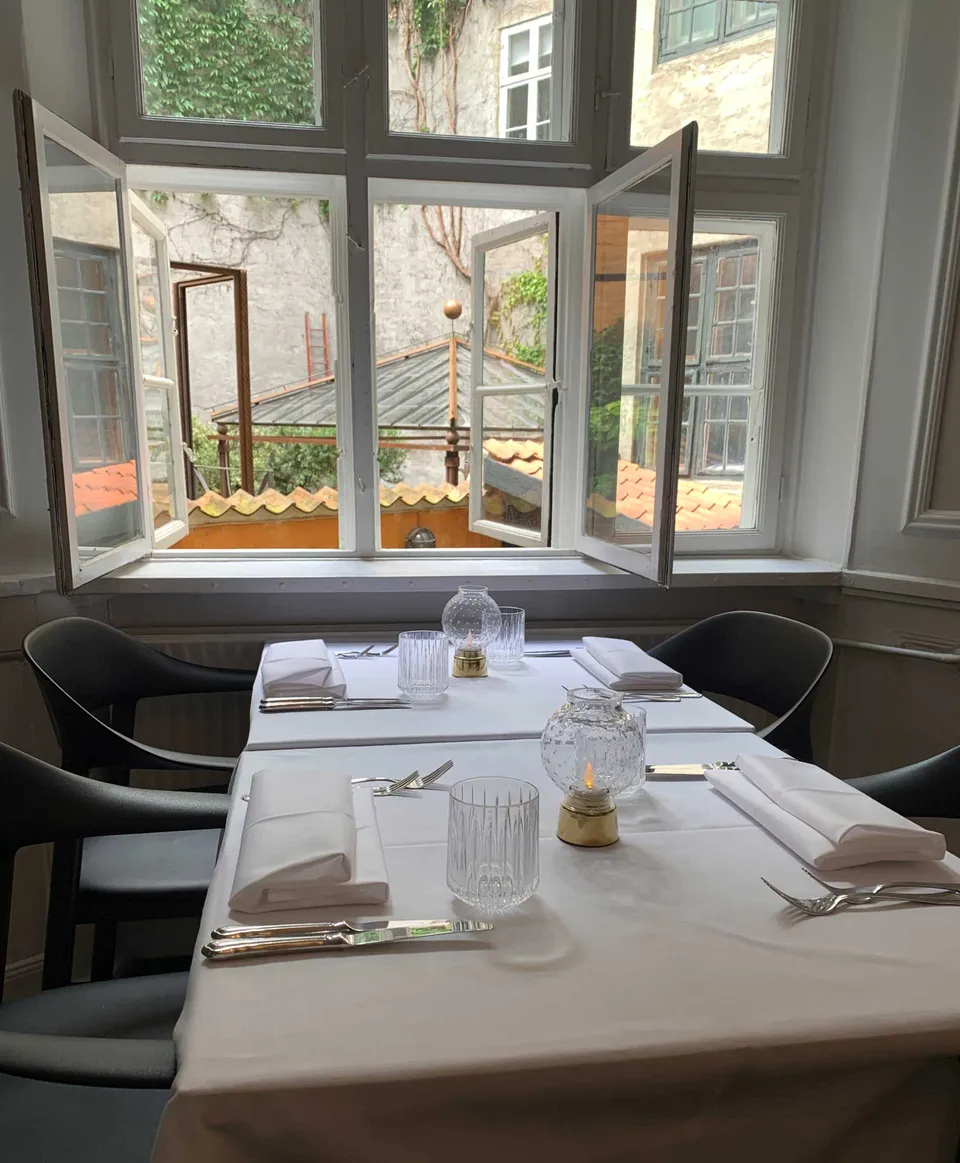 Restaurant Carl Nielsen: Dækket bord ved et stort vindue i et lyst restaurantlokale.