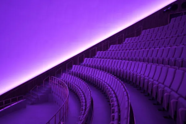 Kuppelsalen v. Planetarium: buede rækker af biografsæder under lilla lys langs kuppelsalens væg.