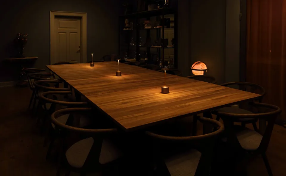 Game room v. Brønnum: Langt træbord med mørke stole i et dæmpet belyst rum.
