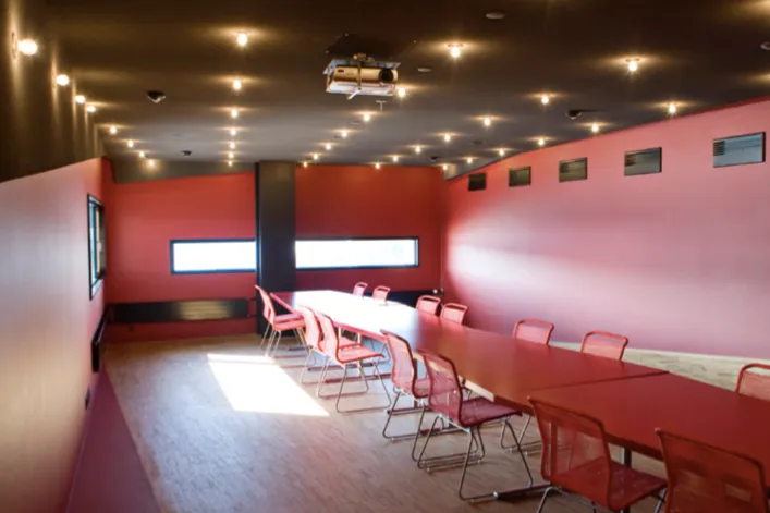 Henckel Lounge v. Skuespilhuset: Langt rødt bord og røde stole i et lokale med røde vægge og smalle vinduer.