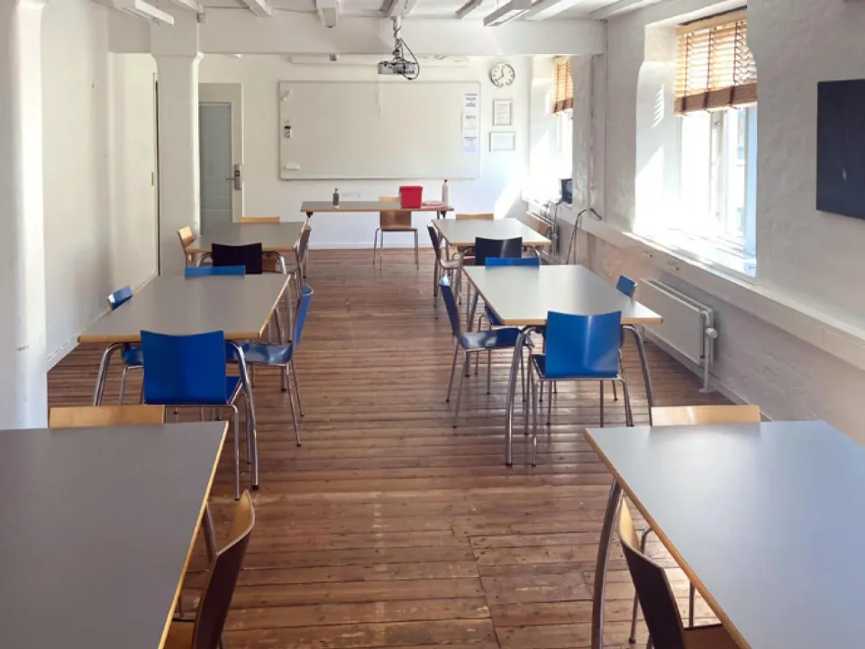 Verdensrummet i Kvarterhuset Amagerbro med borde og blå stole langs vinduerne.