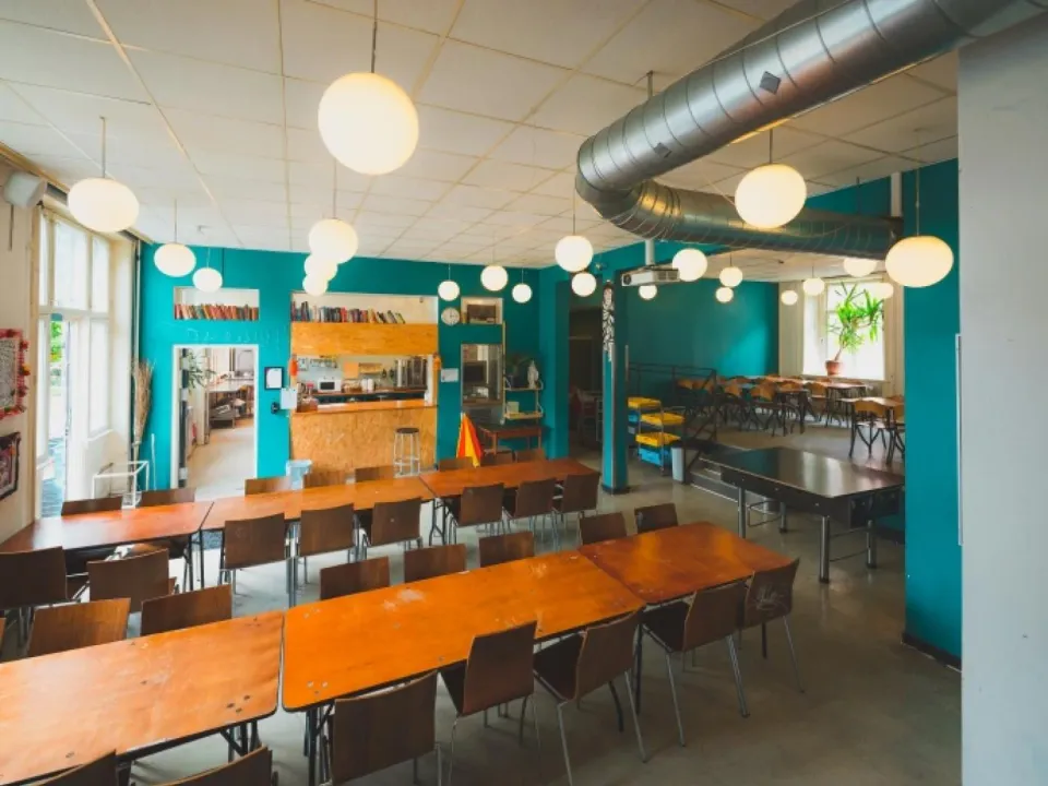 Caféen på Kapelvej44 med bar, grønne vægge og langborde.