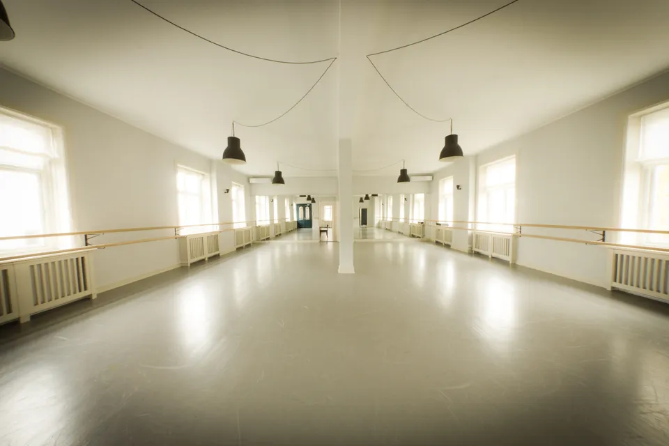 Savery Academy Dance & Performance: Langt lyst danselokale med spejlvæg, barrer og stor åben gulvflade.