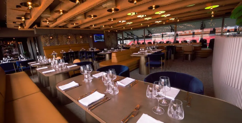 Executive - Bar 7 v. Parken: Executive Bar 7 med spiseborde, synlige loftsrør og stadionvinduer.
