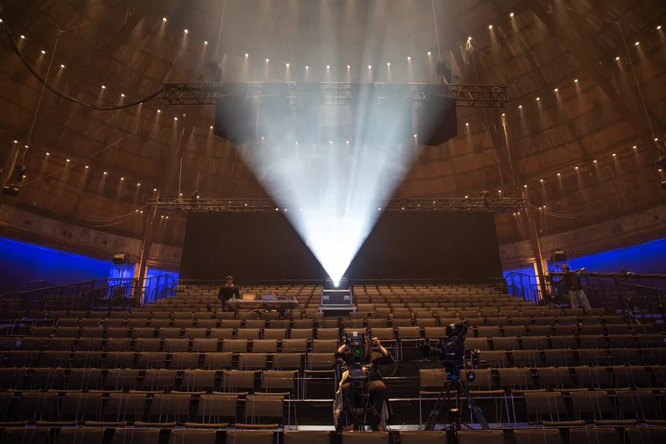 Østre Gasværk Teater: Auditorium med stolerækker under en høj rund loftskonstruktion og en lysstråle.