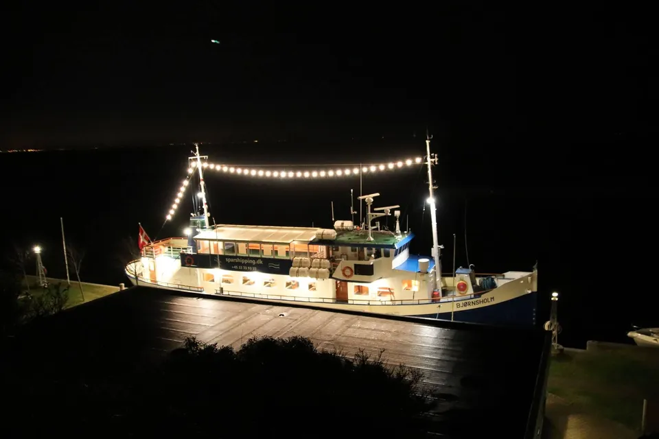 M/S Bjørnsholm v. Spar Shipping: Oplyst passagerskib fortøjet ved bredden om natten.