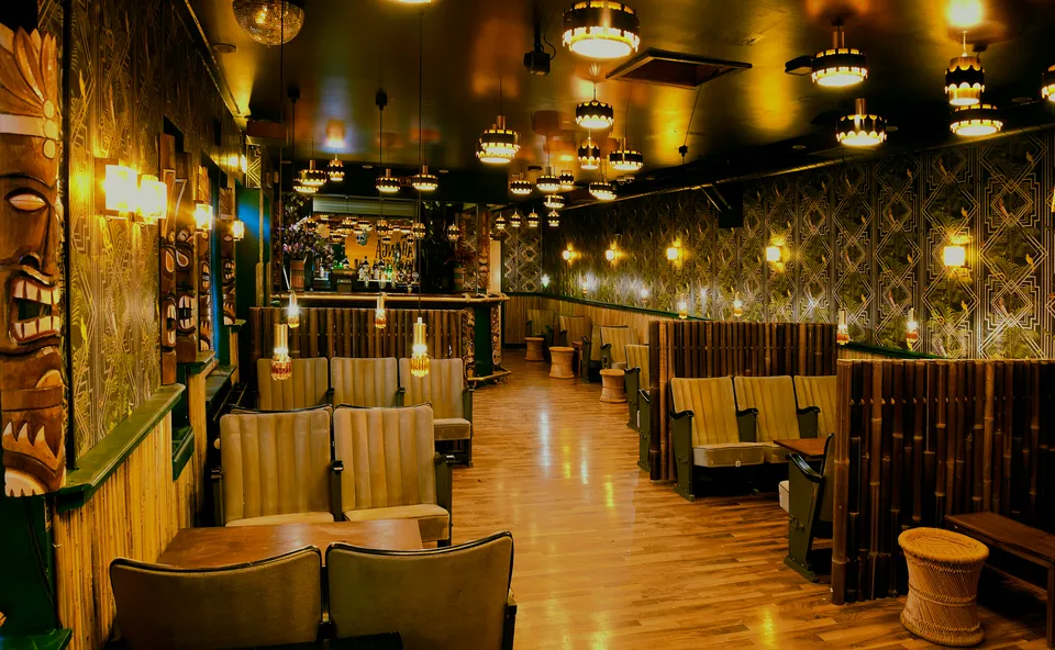 Tahonga Lounge: Lounge med flere siddebåse, trægulv og varm belysning.