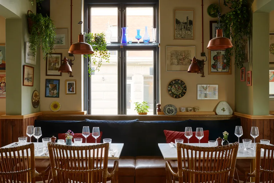 Trattoria Luca: Restaurantens borde og stole under det høje vindue.
