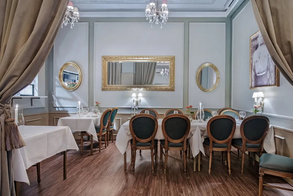 Den Maritime Stue v. Krogs Fiskerestaurant: Spisestue hos Krogs med lyse panelvægge, spejle og dækkede borde.