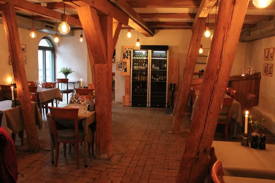 Restauranten v. Oluf Bagers Gård: Restaurantlokale med kraftige træbjælker, flisegulv og dækkede borde.