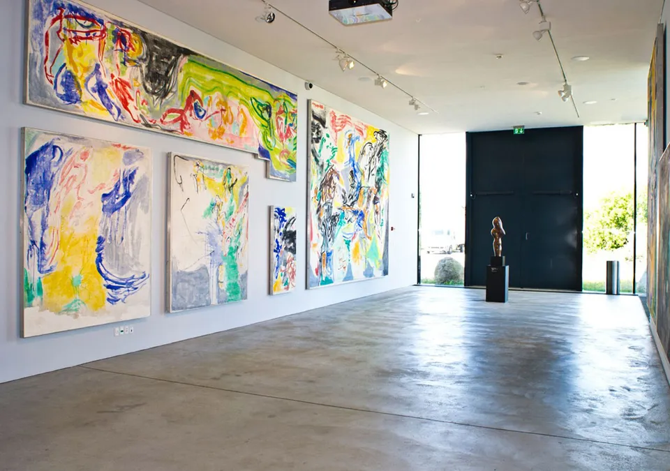 Asger Jorn-Galleri v. ARKEN: Galleri med store farverige malerier på lyse vægge og åben gulvflade.
