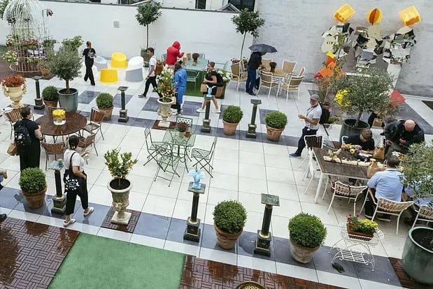 Terrassen v. MBK: Den brede terrasse med borde, planter og gæster set oppefra.