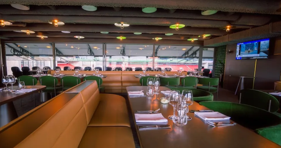 Executive - Bar 4 v. Parken: Executive Bar 4 med borde, sofaer og vinduer mod stadion.