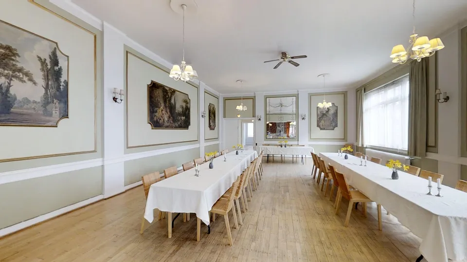 Spejlsalen v. Amagerselskabslokaler: Salens langborde og udsmykkede vægge set fra den modsatte ende.