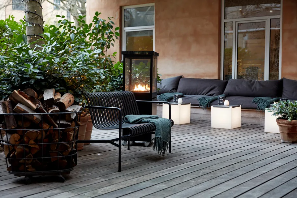 Gårdhaven v. Avenue Hotel Copenhagen: Gårdhave med loungemøbler, træterrasse og en udendørs pejs.