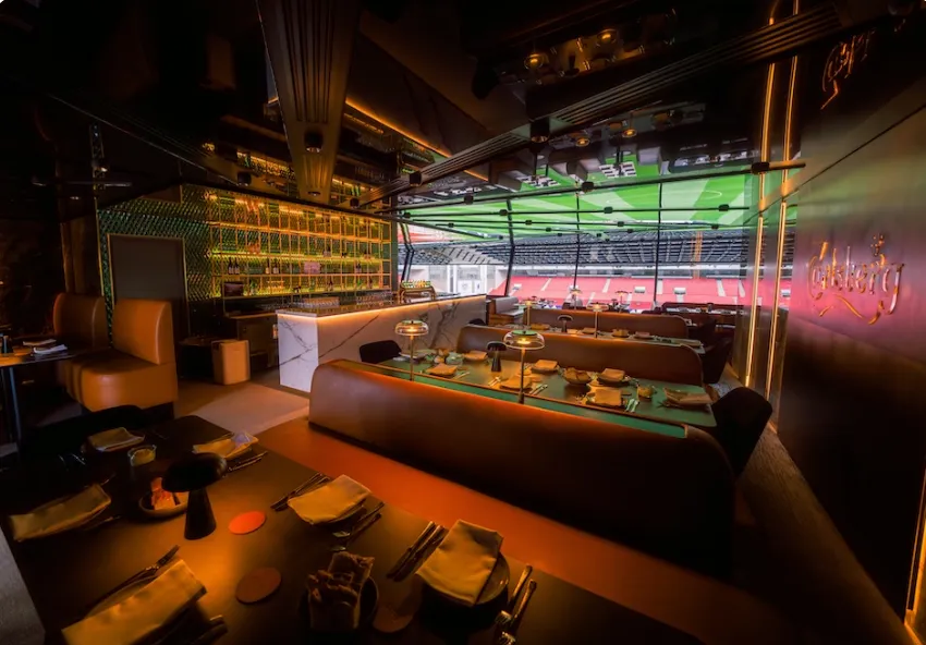 Carlsberg Lounge v. Parken: Loungens borde og barområde med vinduer mod stadion.