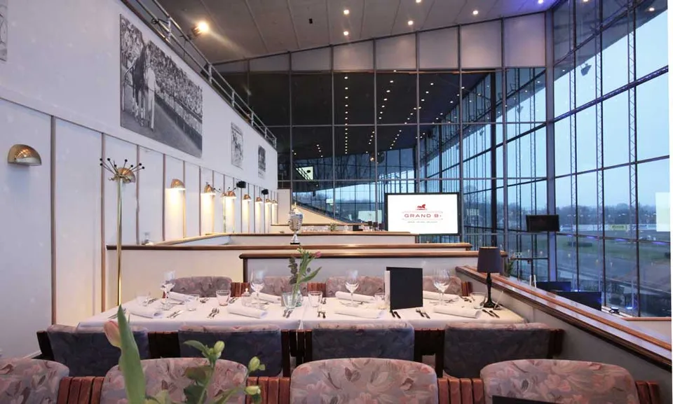Ballroom v. Grand B: Dækkede borde på et langt niveau ved en høj glasfacade.