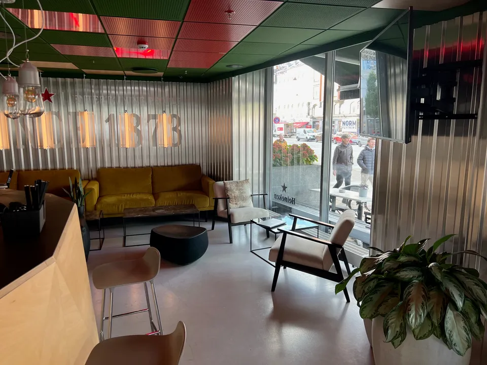 Cube Bar v. Scandic Webers: bar- og loungeområde med sofa, lænestole og store vinduer mod gaden.