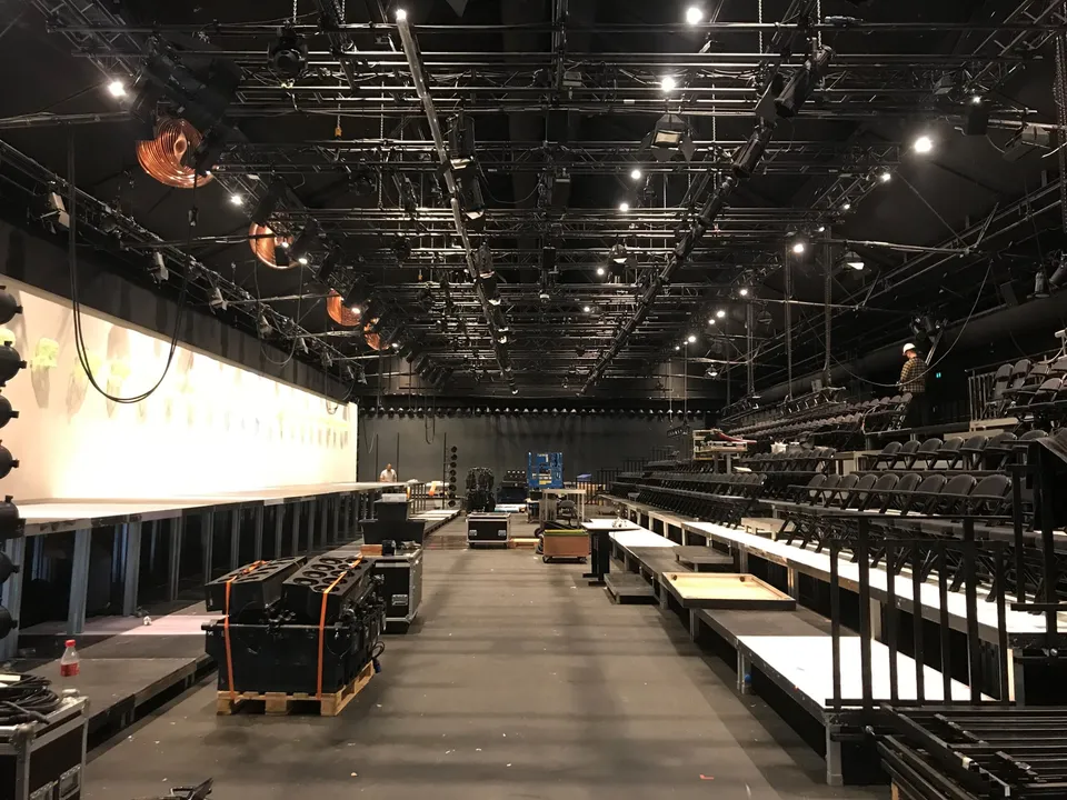 Teater Republique: Teaterrum med lave platforme, trapper og et stort teknisk loftsgitter.