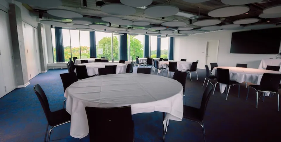 Sky Bar v. Parken: Rummet med runde borde langs det brede vinduesparti.