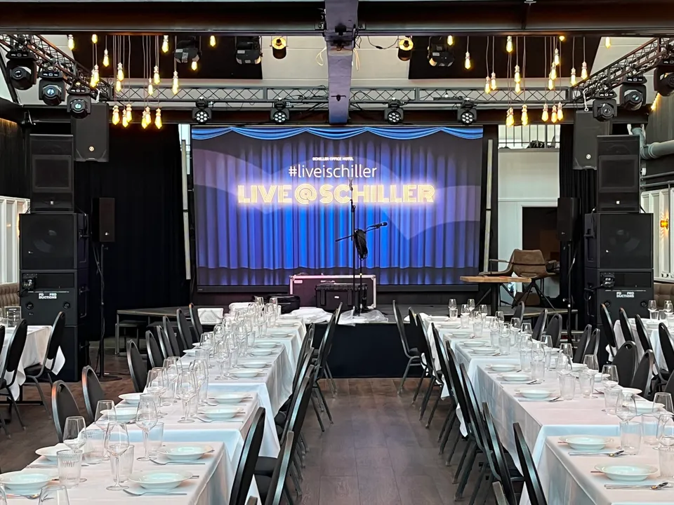 Ballroom 1+2 v. Schiller Office Hotel: Langbordopstilling med scene, skærm og diskokugler i galleri for Ballroom 1 + 2.